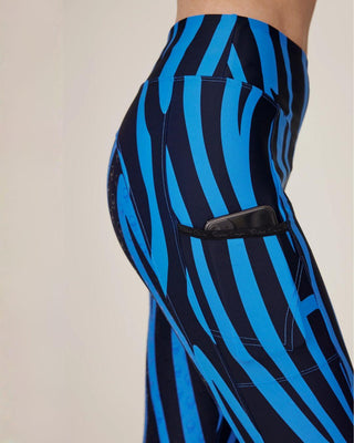 Close-up van het telefoonzakje op het rechterdijbeen, met het anti-slip siliconenlogo op de blauwe zebrastof.