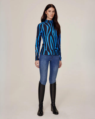 Volledig frontaal aanzicht van de blauwe zebra-rijtop, gestyled met originele denim rijbroek voor een klassieke maar gedurfde look.