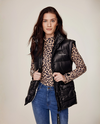 Medium vooraanzicht van een model dat de Leo rijtop styled onder een zwarte puffer bodywarmer met originele denim rijbroek.