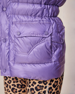 Close-up van de praktische voorzak op het lila riding vest, waarbij het functionele ontwerp wordt uitgelicht.