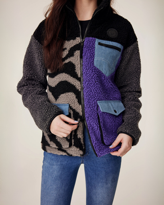 Close-updetail van de functionele tweewegritssluiting op het lila en zebra teddyjack, ontworpen voor comfort in het zadel.