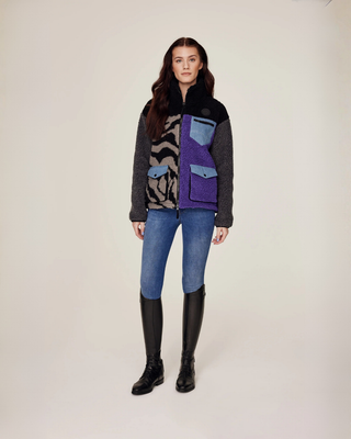 Volledig vooraanzicht van een model dat het dichtgeritste lila en zebra teddyjack draagt voor een comfortabele paardensportlook.