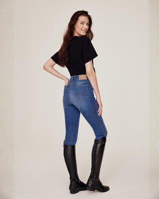 Volledig lichaamsbeeld schuin van achteren van een model gestyled in Riders Denim original jeans rijbroek en een zwart equestrian t-shirt.