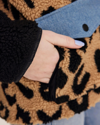 Close-up van de voorzakken op de teddyjas, waarbij het functionele ontwerp en de accenten van denimstof worden benadrukt.