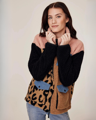 Modieuze pose van een model die het unieke colourblock-design van de teddyjas in beige, luipaard en roze toont.