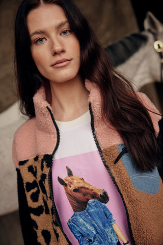 Lifestyleshot met het witte T-shirt met paardenprint, gelaagd onder de roze en leo teddyjas.